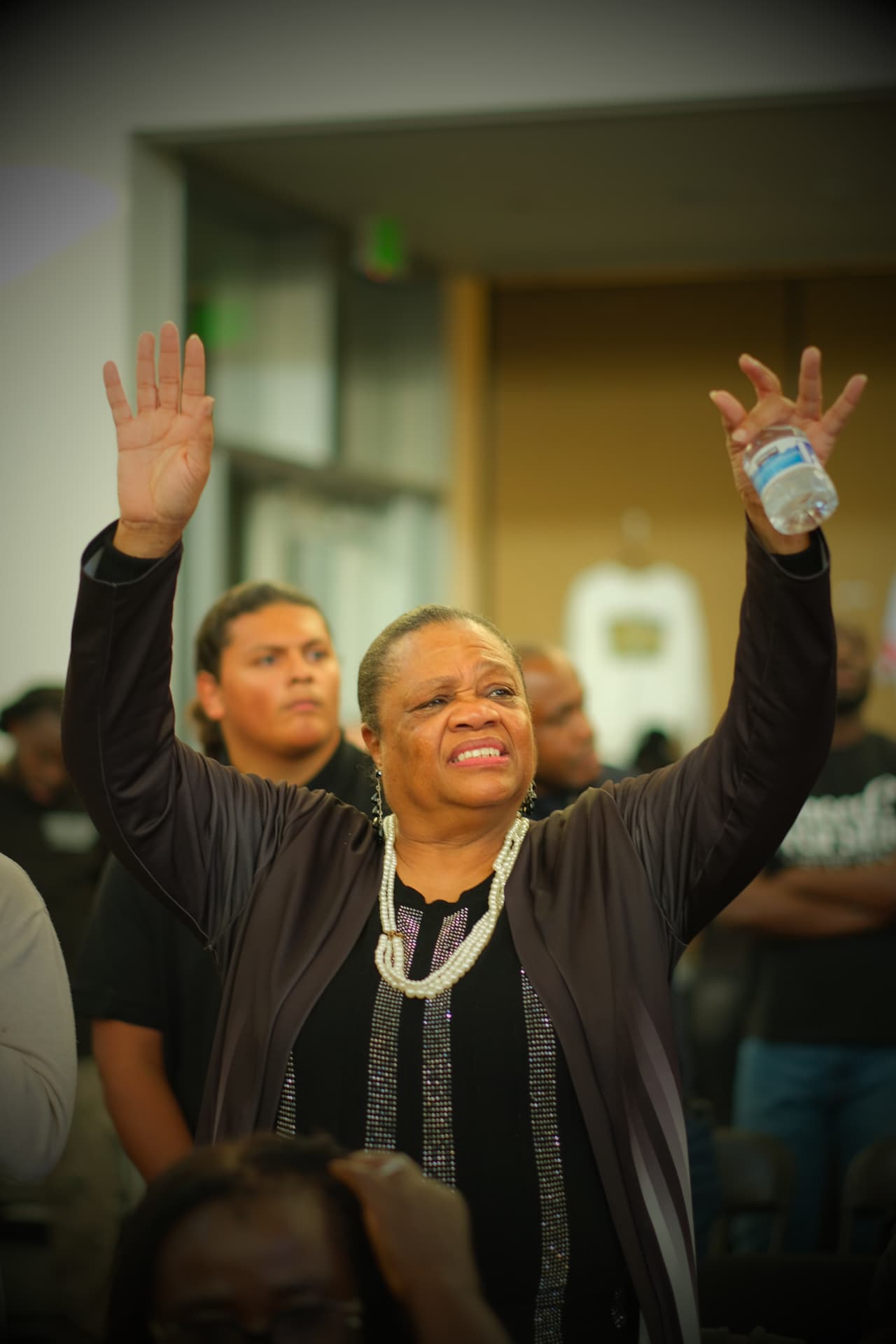 A PIWC Bay Area member with hands lifted in prayer