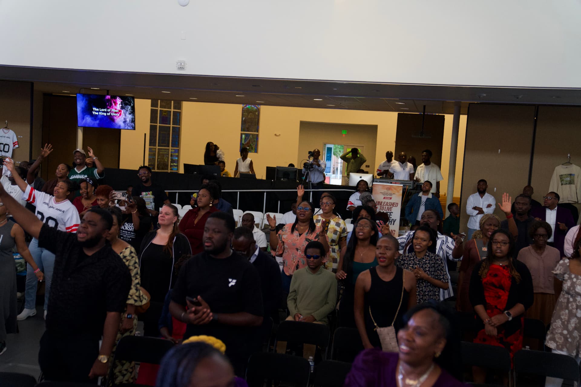 PIWC Bay Area worshippers with hands raised during Sunday service